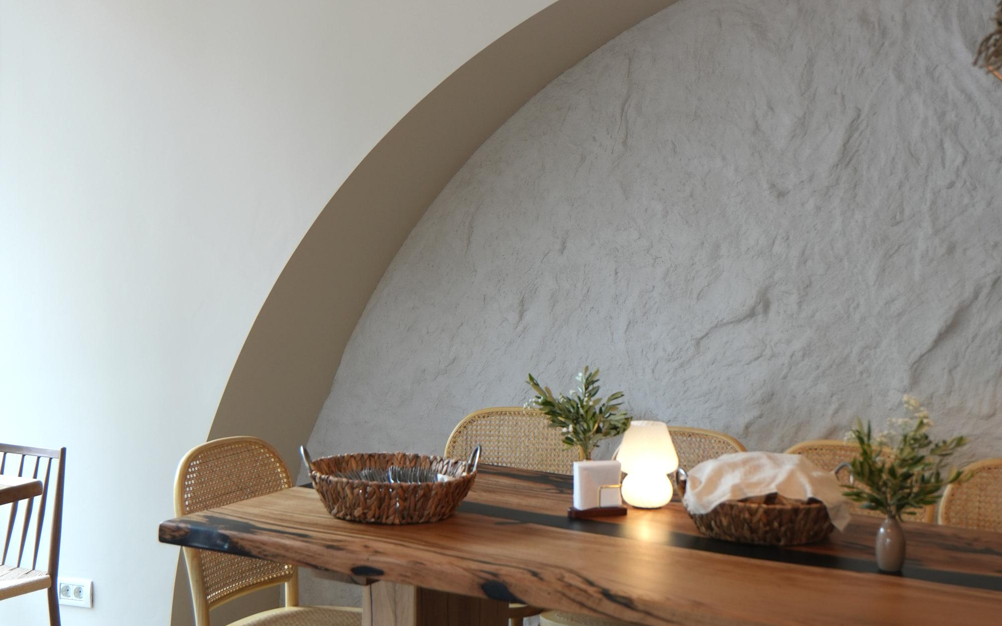 Sala restaurantului HRANA, Hunedoara: arcada albă, lampa împletită și masa lungă din lemn