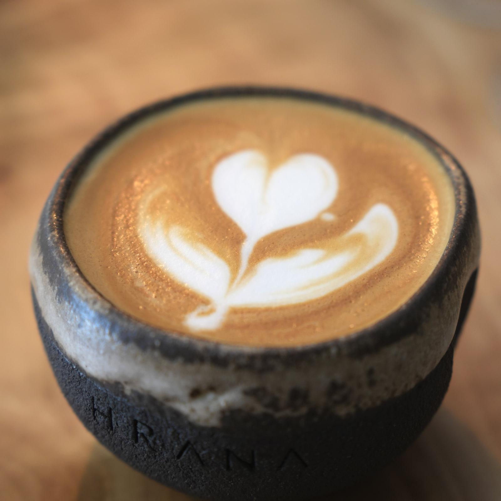 Cappuccino cu latte art într-o ceașcă de ceramică HRANA