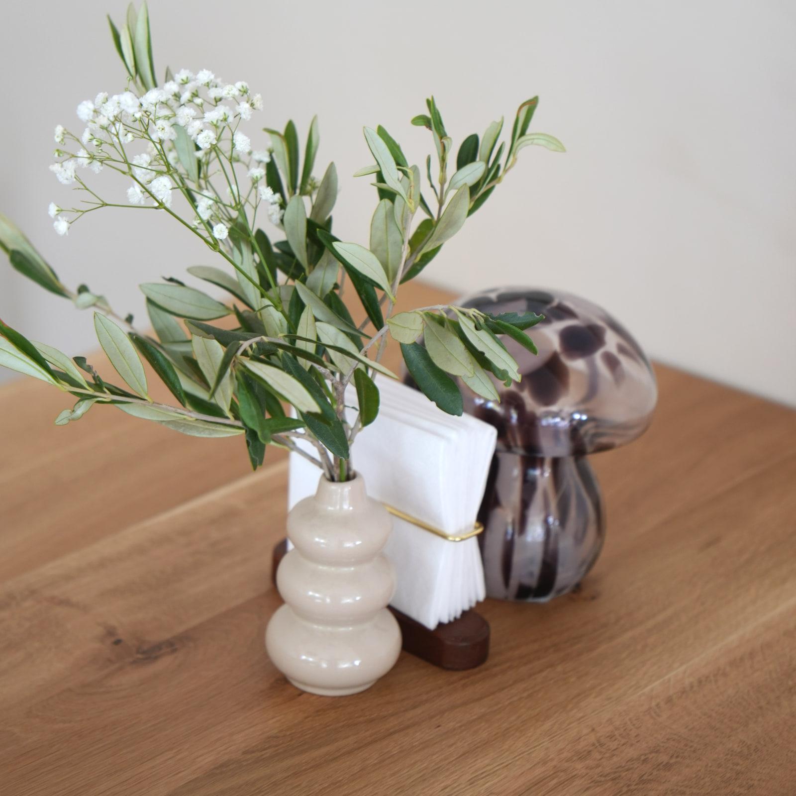 Crenguță de măslin într-o vază de ceramică pe masa din lemn, la HRANA